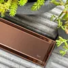 A close-up view of a copper shower drain with plants in the background. Produktbild-Vorschau