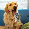 A golden retriever dog with its mouth wide open, about to bite a plush fish toy. Produktbild-Vorschau