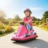 A young girl is happily riding a pink toy car in a park-like setting with flowers and trees. Náhľad obrázku produktu