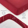 A close-up view of a red fitted sheet, showing its elasticized edge and some product feature callouts. Produktbild-Vorschau