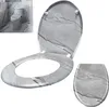 A toilet seat and lid with a marble pattern, shown separately and also as part of a toilet in a bathroom setting. Produktbild-Vorschau