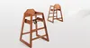 Two wooden high chairs are shown against a white background. The chair in the foreground is angled slightly towards the viewer, while the chair in the background is further away and angled more to the side. Podgląd zdjęcia produktu