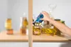 A hand reaching for a can on a shelf with various food items. Anteprima dell’immagine prodotto