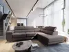 A modern living room with a large sectional sofa, coffee table, and stairs leading to an upper level. Produktbild-Vorschau