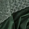 A close-up view of two different green fabrics, one with a sequined pattern and the other a plain velvet. Produktbild-Vorschau