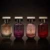 Four bottles of Hugo Boss The Scent for Her perfume are displayed in a studio setting with a dark background. Voir les images du produit