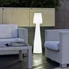 An outdoor patio scene with furniture and a large floor lamp. Anteprima dell’immagine prodotto