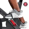 A close-up shot of a person's feet on the pedals of an indoor cycling bike. Voir les images du produit
