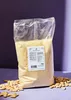 A bag of almond flour with loose almonds scattered around it, set against a purple and dark gray background. Produktbild-Vorschau