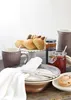 A breakfast setting with baked goods, jam, and a mug. Produktbild-Vorschau