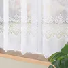 A close-up view of white lace curtains hanging over a window. Náhled obrázku produktu