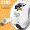 Close-up of a white portable sewing machine showing its battery compartment and USB charging port, with a power strip and charger in the background. Produktbild-Vorschau