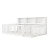 A white wooden crib with a bookshelf attached to the headboard, shown from a side angle against a white background. Produktbild-Vorschau