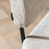 Close-up of a chair's armrest and leg, showing a fabric tag. Produktbild-Vorschau