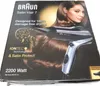 The image shows the packaging of a Braun Satin Hair 7 hair dryer. The packaging features an image of the hair dryer and a model with healthy hair, along with product specifications and branding. Produktbild-Vorschau
