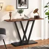 A console table with decorative items on top, placed against a wall with a picture frame and a lamp. Podgląd zdjęcia produktu