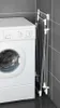 A clothes drying rack is shown next to a washing machine in a bathroom. Náhled obrázku produktu