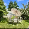A patio set with a large umbrella in a backyard setting. Anteprima dell’immagine prodotto