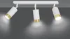 A white track light fixture with three adjustable spotlights, each with a gold accent ring, is mounted on a white ceiling against a gray wall. The lights are illuminated, casting a warm glow downwards. Podgląd zdjęcia produktu