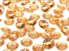 A scattering of gold-colored diamond confetti pieces on a white background. Náhled obrázku produktu