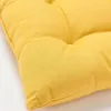 A close-up view of a yellow tufted cushion. Produktbild-Vorschau