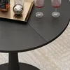 A close-up view of a black round table with two glasses of red wine and a bottle of whiskey on a golden tray. Anteprima dell’immagine prodotto