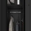 Interior view of a black wardrobe with clothes hanging on a rod. Produktbild-Vorschau