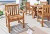A wooden garden furniture set on a wooden deck with a beach and ocean in the background. Produktbild-Vorschau
