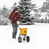 A person is using a yellow spreader in the snow. Produktbild-Vorschau