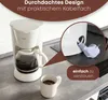 A white coffee maker with a glass carafe filled with coffee, and a white mug with coffee next to it, on a kitchen counter. A close-up inset shows the power cord being stored in a compartment at the back of the coffee maker. Anteprima dell’immagine prodotto