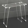 A silver and white drying rack is shown against a gray tiled background. Náhled obrázku produktu