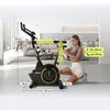 A woman is using a stationary bike in a modern living room. Produktbild-Vorschau