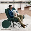 A man is sitting in a rocking chair holding a small white dog. The chair is dark green and appears to be made of corduroy. The room has wooden floors and a rug. Produktbild-Vorschau