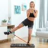 A woman is exercising at home using a portable fitness system. Podgląd zdjęcia produktu