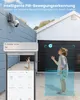 A child is looking up at a security camera mounted on a wall, with a smartphone displaying the camera feed in the foreground. Náhled obrázku produktu