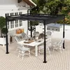An outdoor patio scene with a dining table and chairs set up under a black pergola. Náhled obrázku produktu