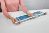 A person's hands are shown operating a paper cutter on a white table. Voir les images du produit