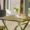 A small, round rattan-look table with two glasses of yogurt parfait and a vase of flowers on a patio. Anteprima dell’immagine prodotto