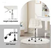 A cream-colored office stool with wheels is shown in a room with a vanity table in the background. Produktbild-Vorschau