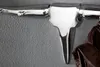 A silver coat rack with a bull head design, hanging on a textured gray wall. A brown leather jacket is hanging on the coat rack. Produktbild-Vorschau
