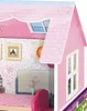 A close-up view of a pink dollhouse with a pitched roof and windows. Náhľad obrázku produktu