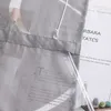 A close-up view of a gray fabric with text printed on it, possibly a curtain or textile sample, with some transparent plastic elements and a white string. Produktbild-Vorschau