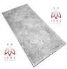 A rectangular panel with a concrete-like texture, presented at an angle on a white background. Two identical logos are placed in opposite corners. Produktbild-Vorschau