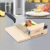 A kitchen slicer with a wooden base and a metal blade, slicing a piece of meat on a cutting board. Náhled obrázku produktu