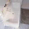 A white bathtub in a modern bathroom with marble-like walls and floor. Produktbild-Vorschau