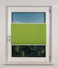 A window with a green pleated blind partially covering it, showing a view of trees and sky. Produktbild-Vorschau