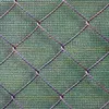 A close-up view of a chain-link fence with a green mesh screen behind it. Podgląd zdjęcia produktu