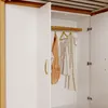 Interior view of an open wardrobe with clothes hanging on a rod. Anteprima dell’immagine prodotto