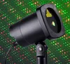 A black laser projector emitting red and green dots onto a green background. Produktbild-Vorschau