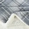 A close-up view of a folded plaid blanket with a sherpa lining. Produktbild-Vorschau